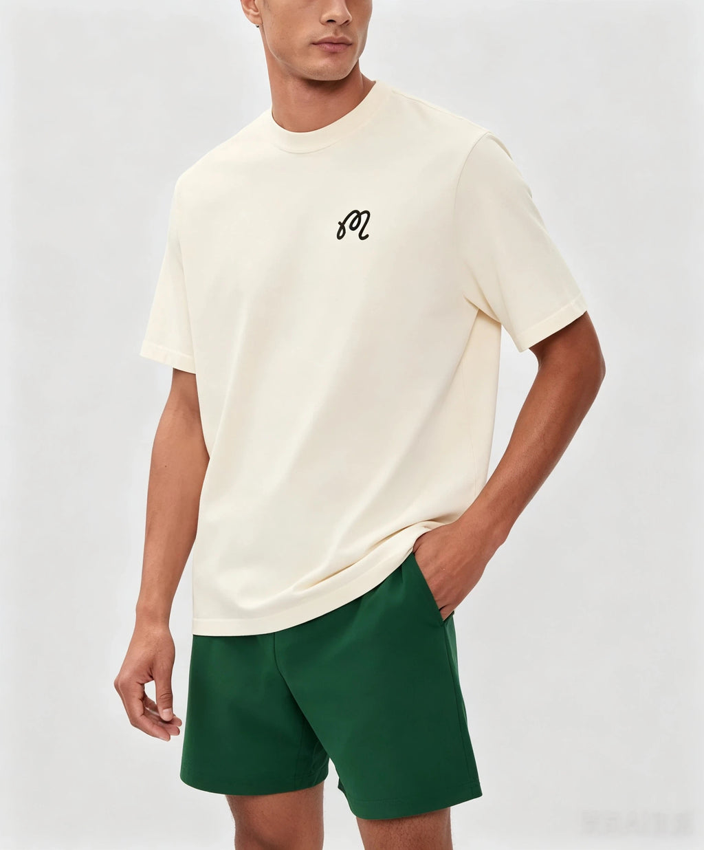 Model wearing Malbon beige graphic T-shirt front view