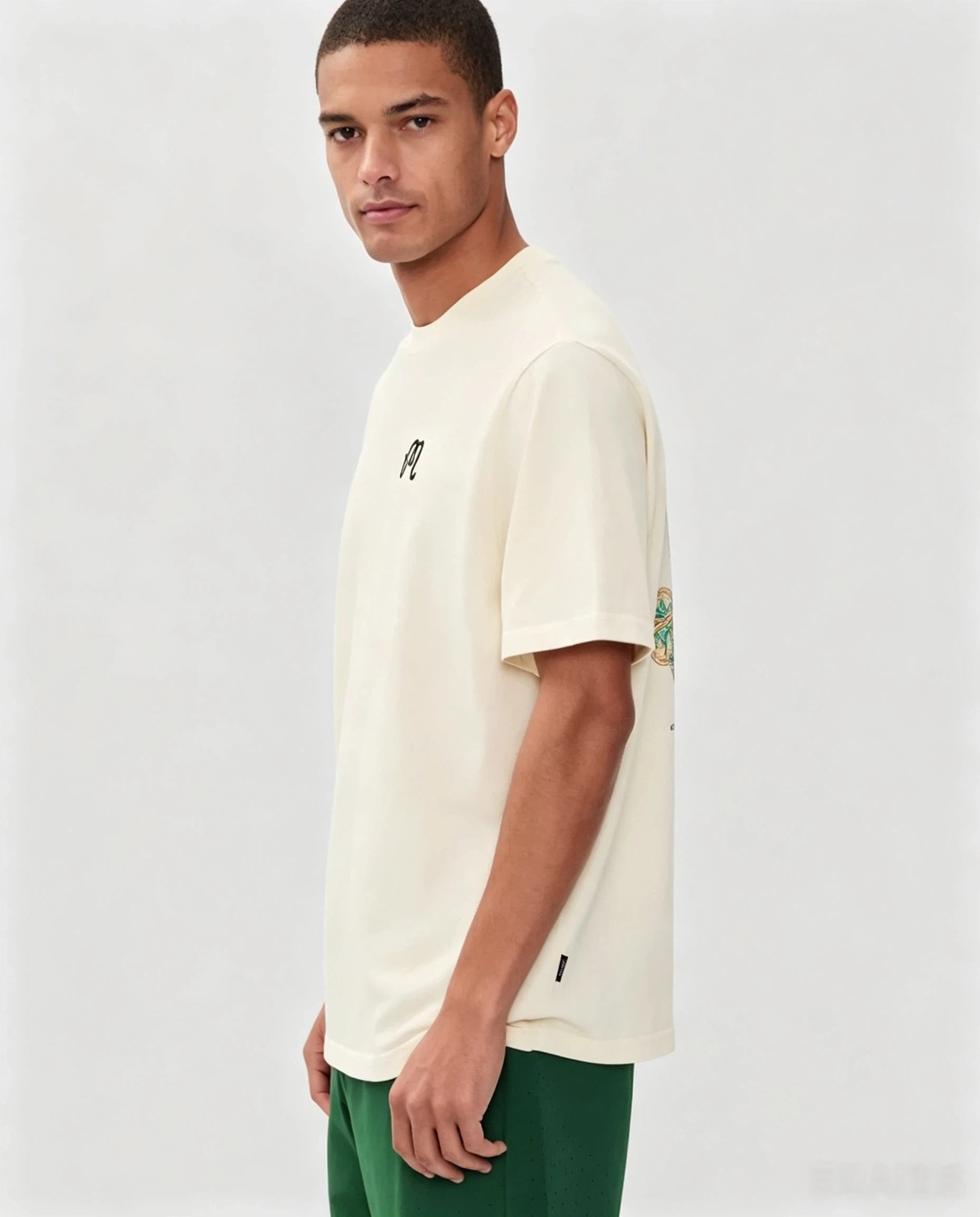 Model wearing Malbon beige graphic T-shirt side view
